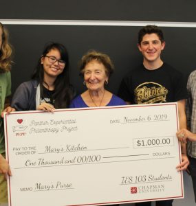 five people with giant check