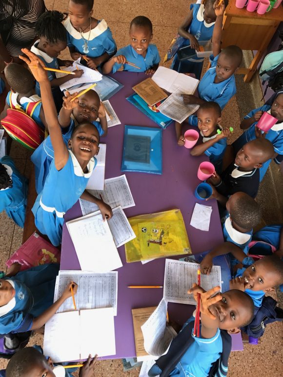 students at a table in the Nakuwadde Center in Uganda