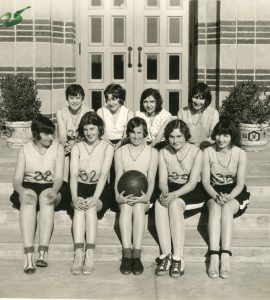 Women in vintage uniforms pose for basketball team shot in the 1920s