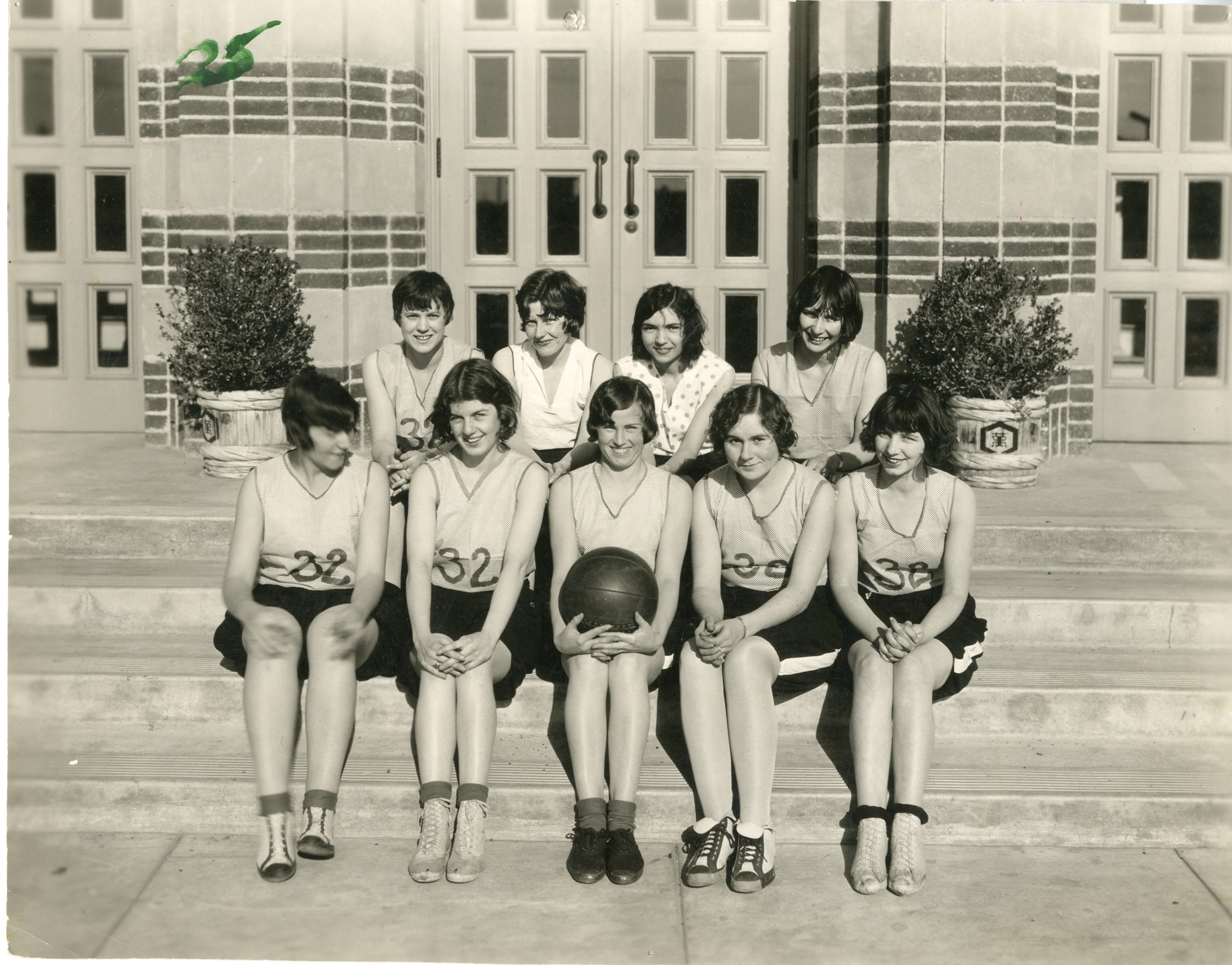 Women in vintage uniforms pose for basketball team shot in the 1920s