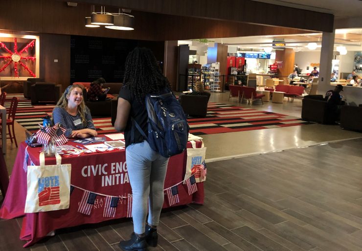 Cydney Hansen ’22 helps students register to vote at Civic Engagement’s voter registration table on campus.