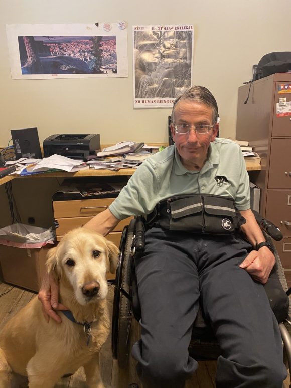 Man who uses a wheelchair next to dog