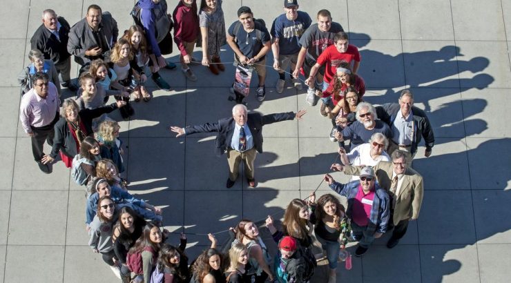 Attendees gather together and pose forming the shape of an O-ring.