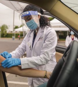 A Chapman University Pharm.D. student administers a seasonal flu shot at one of several drive-through immunization clinics hosted by Chapman.