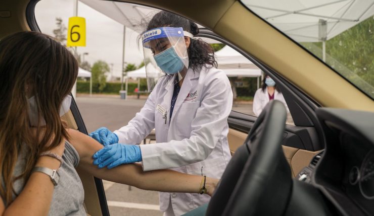 A Chapman University Pharm.D. student administers a seasonal flu shot at one of several drive-through immunization clinics hosted by Chapman.