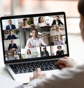 Person seated at workplace desk participating in an online meeting.