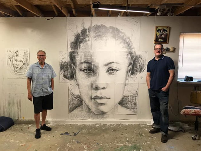 Artist and Hilbert founder pictured standing on opposite ends of large portrait of woman.