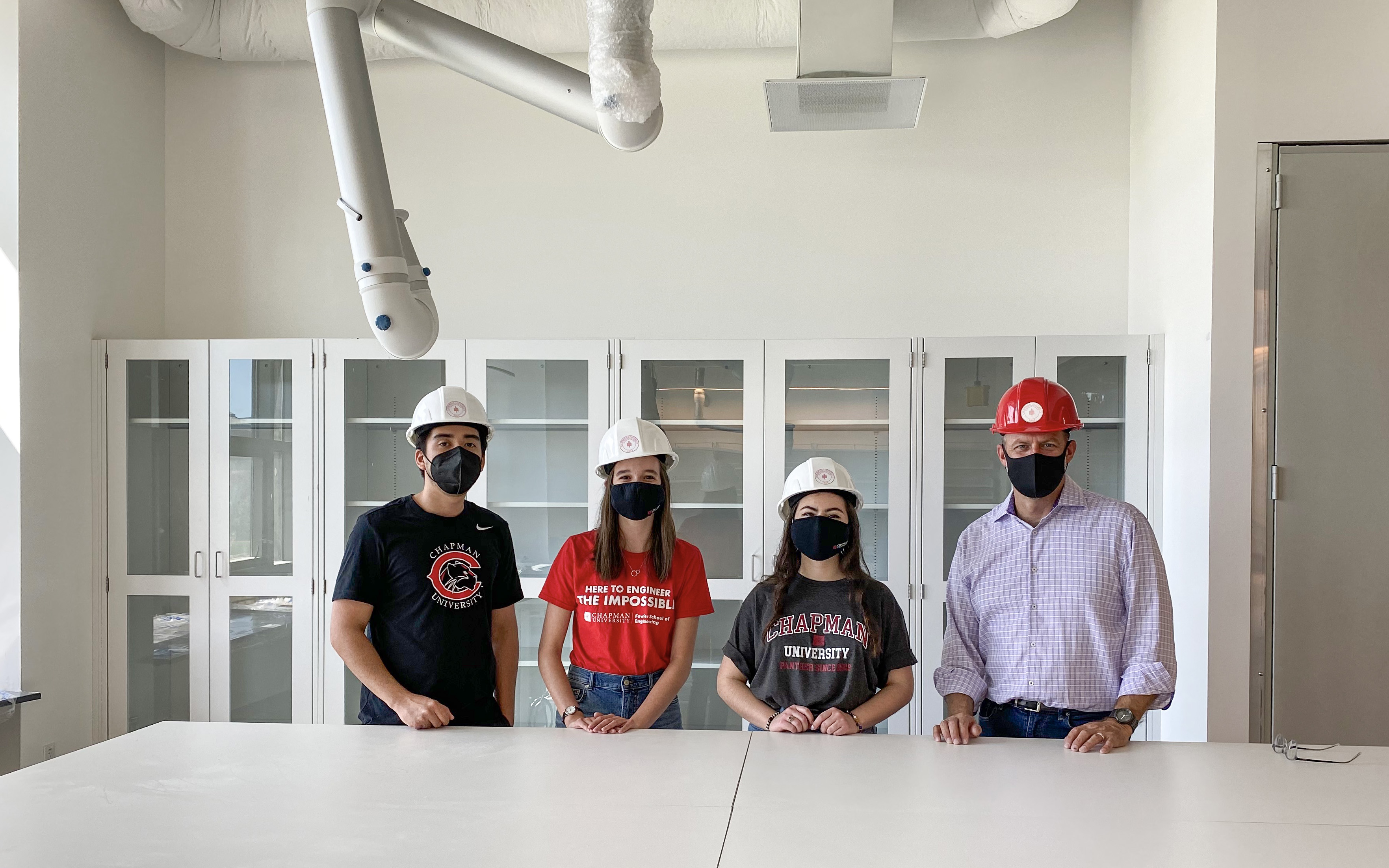 Dean Andrew Lyon and three students in Swenson Hall lab space. 