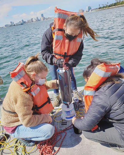 Student Emma Kocik does aquatic resarch on a dock.