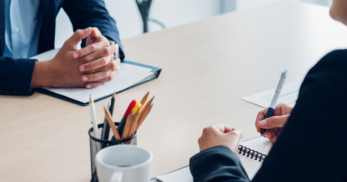 two people sitting across from each other in a meeting.