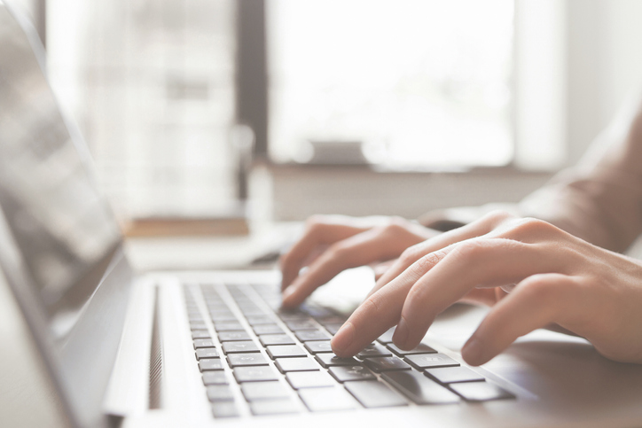 Person typing on laptop.