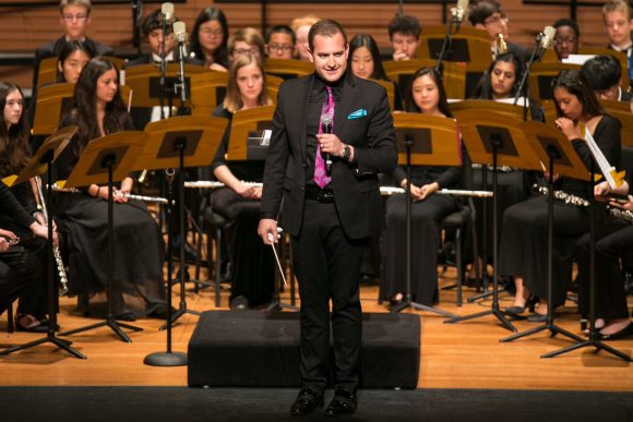 Teren Shaffer conducts wind ensemble during a concert.