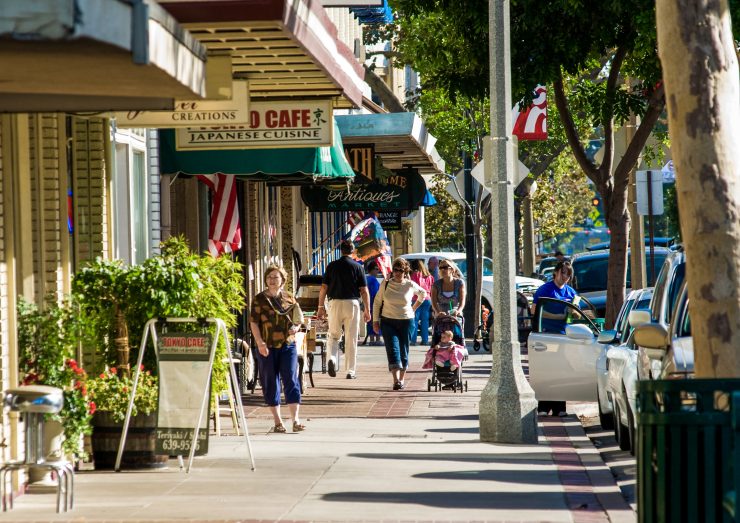 Image of people walking on sidewalk in downtown shopping area