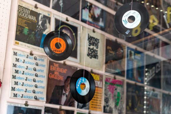 Vinyl records hang in front of a window at an Old Towne Orange music shop.