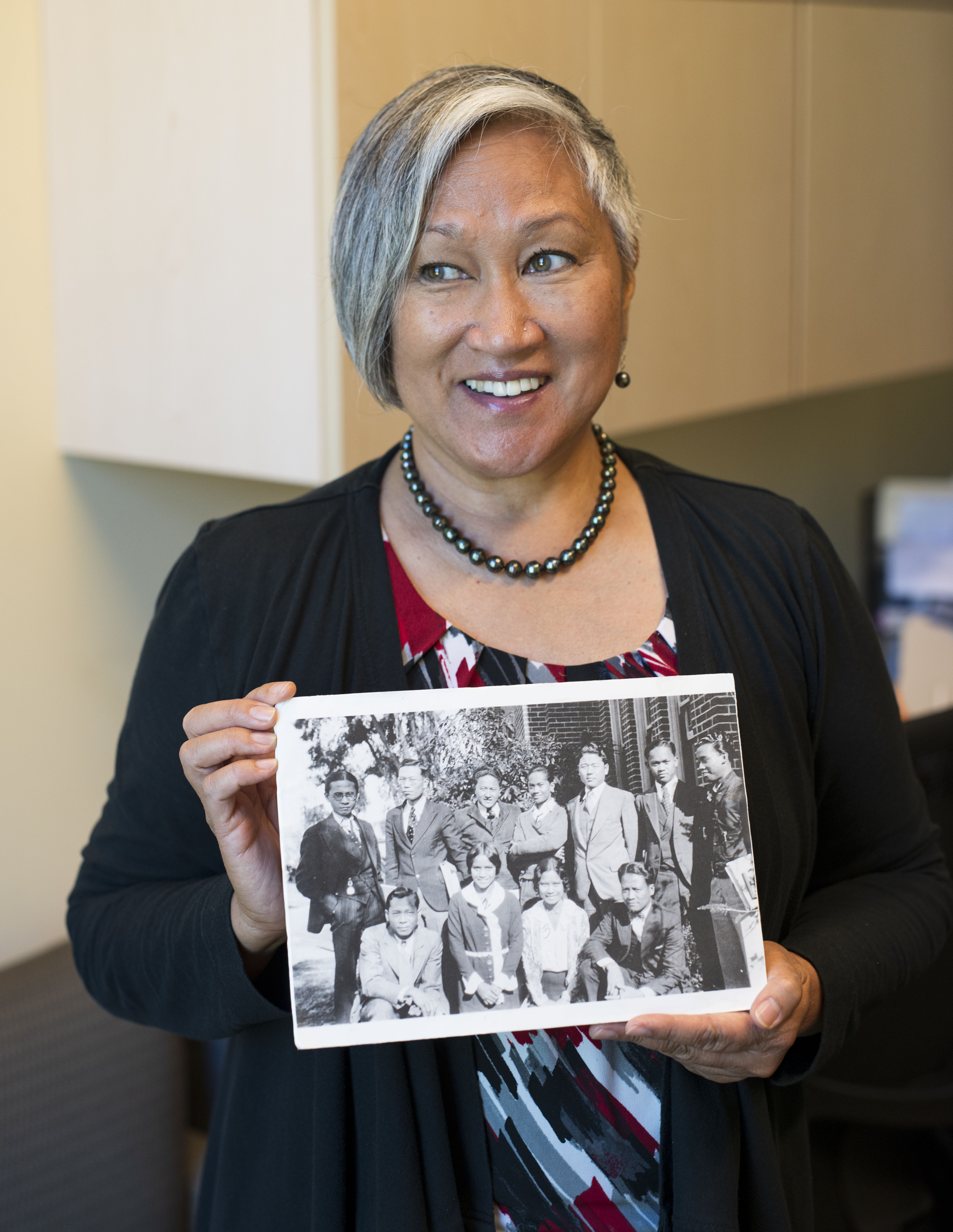 The Rev. Cisa Payuyo holds a photo of Filipino Panthers students from the 1930s. 