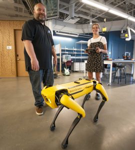 Erik Linstead and student with robot dog.