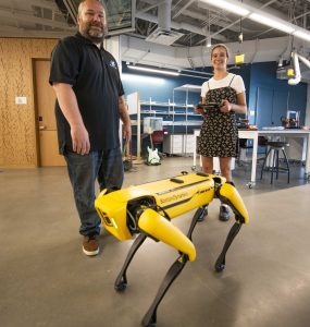 Erik Linstead and student with robot dog.