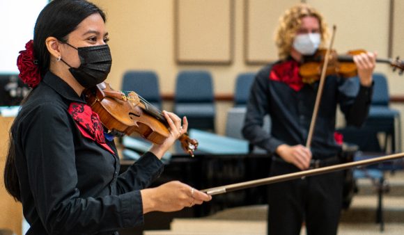 Two mariachi musicians rehearsing in music room at Chapman