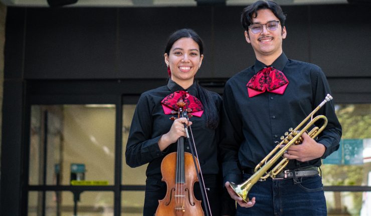 Two mariachi students at Chapman holding instruments.