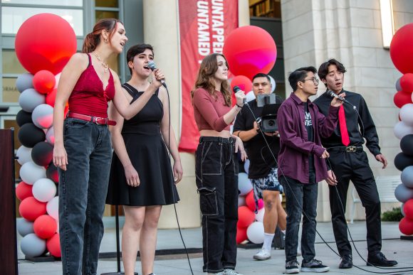 young men and women singing on outdoor stage