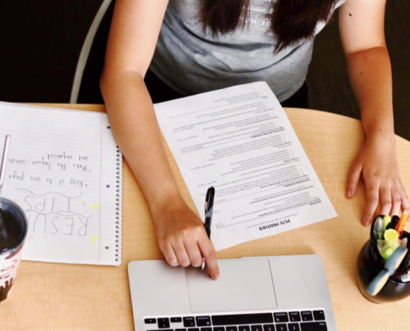 overhead shot of person sitting at a desk looking at a resume