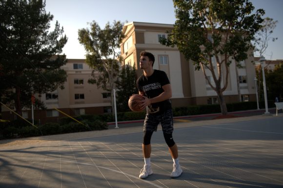 man outdoors about to shoot basketball