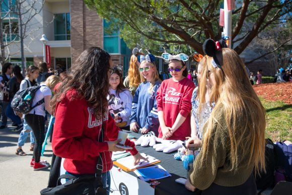 students standing around outdoor information table