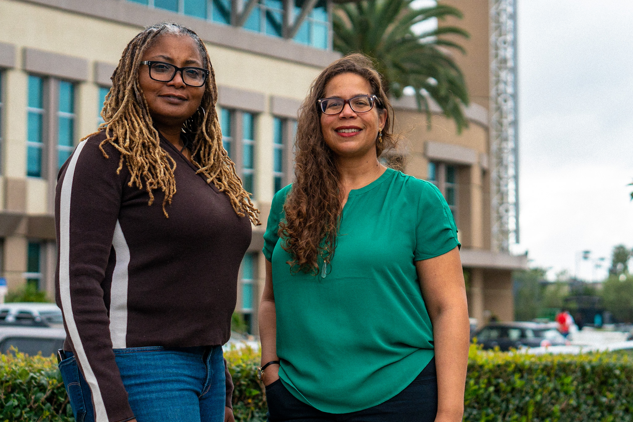 Leah Aldridge and Charissa Threat pose in front of Dodge College 