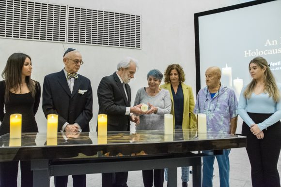 Holocaust survivors and members of subsequent generations light commemorative candles at Wallace All Faiths Chapel at Chapman University.
