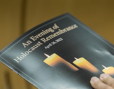 Image of the event program, which reads: An Evening of Holocaust Remembrance" and features a lit candle.