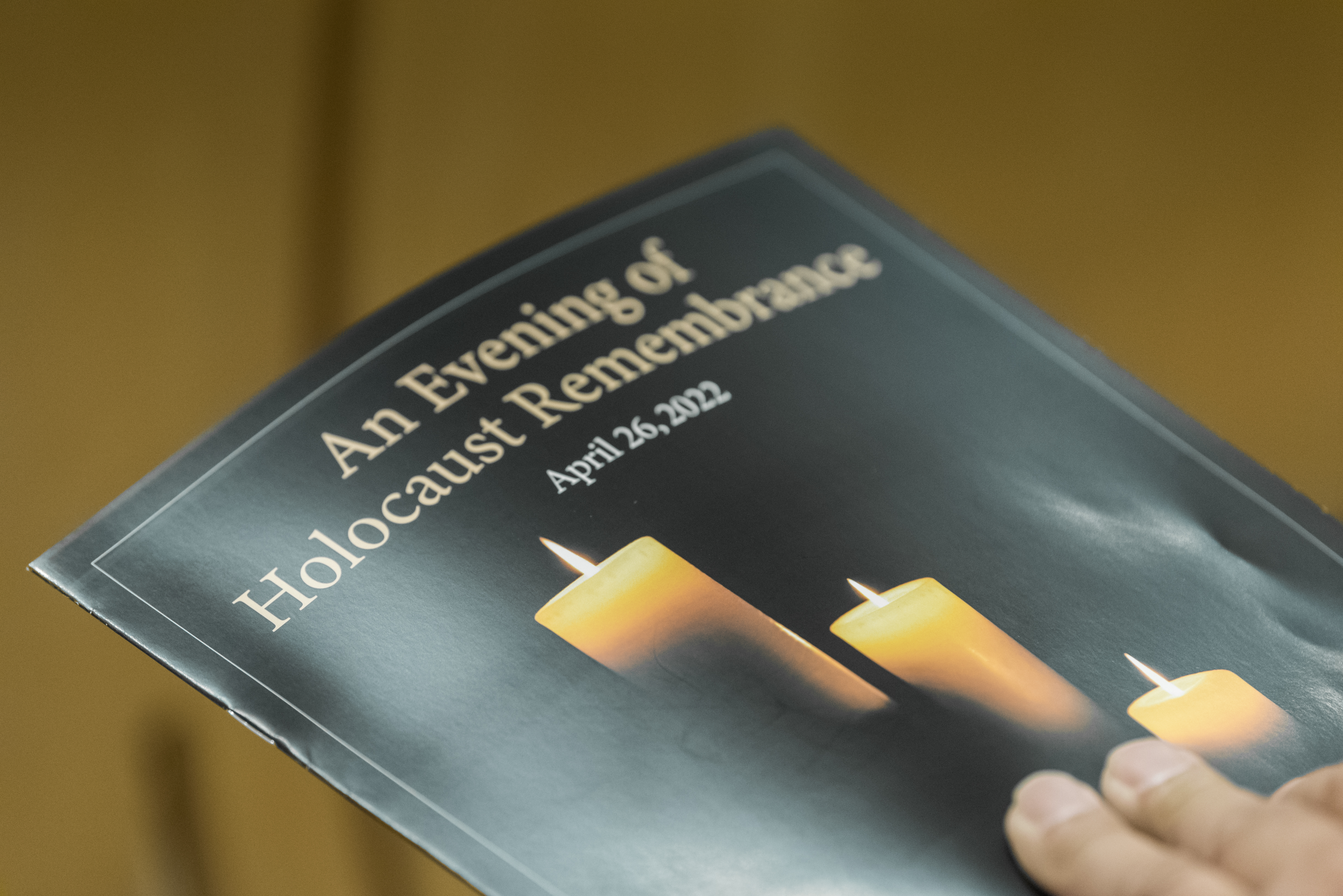 Image of the event program, which reads: An Evening of Holocaust Remembrance" and features a lit candle.