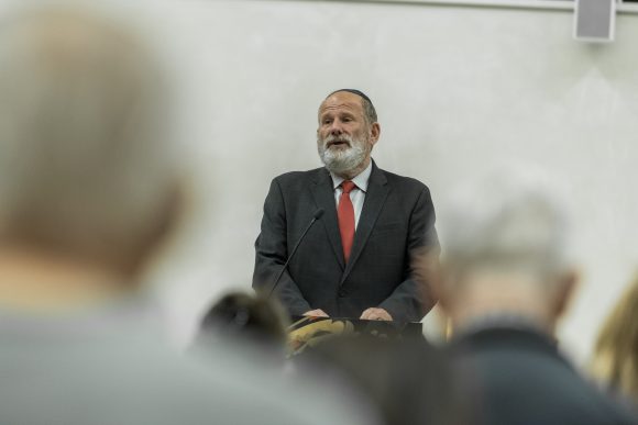 Cantor Chayim Frenkel sings Jewish prayers for peace to a blurred audience.