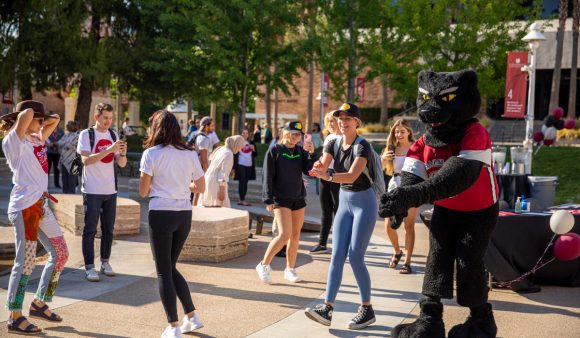 Pete the panther dances with students in attallah piazza