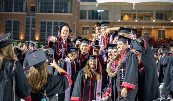 grads in caps and gowns posing for pics