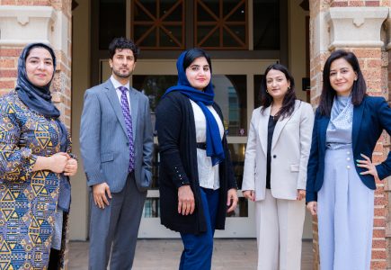 five afghan scholars standing on steps