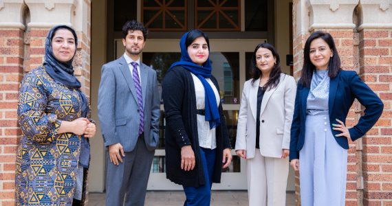 five afghan scholars standing on steps