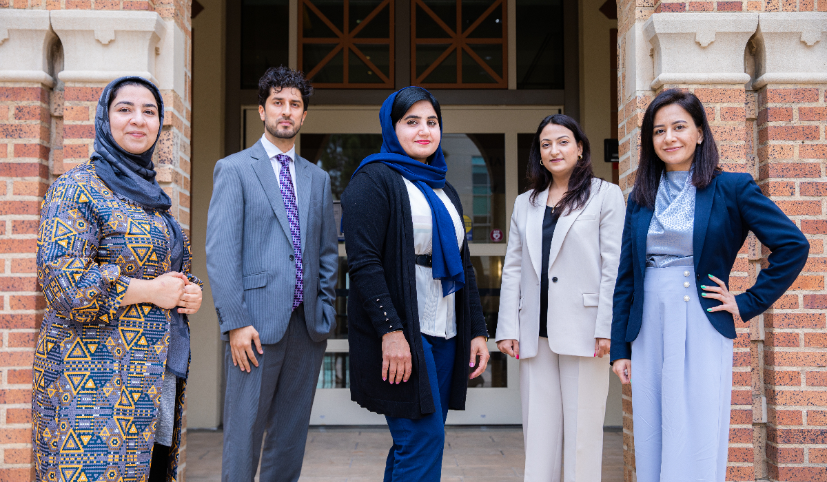 five afghan scholars standing on steps