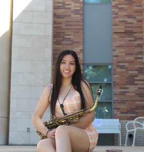 erandi sanchez sitting on steps with saxophone