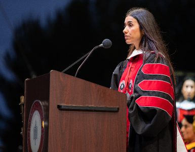 nadia murad in academic robe behind podium