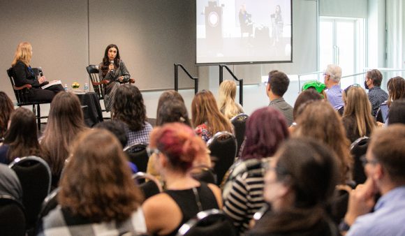 jennifer keene and nadia murad sitting on stage