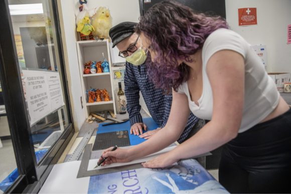 Premeau and Chimenti cutting the poster