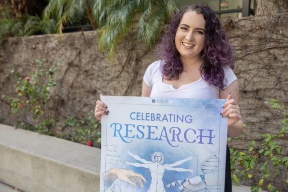Alice Premeau holding the poster she designed