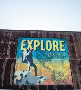 old building faced with large poster that reads EXPLORE CHAPMAN UNIVERSITY