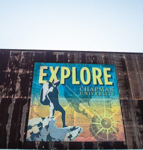 old building faced with large poster that reads EXPLORE CHAPMAN UNIVERSITY