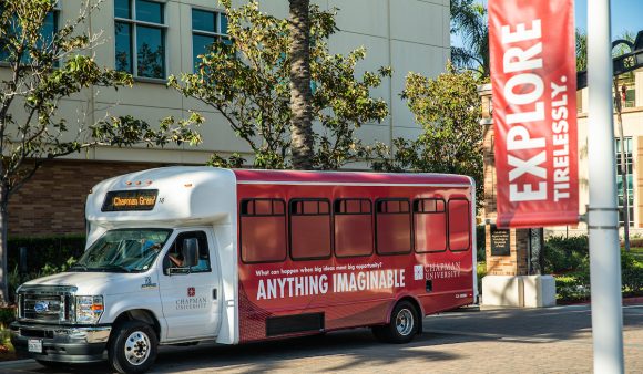 shuttle bus with red "Anything Imaginable" wrap, and "Explore Tireless" banner in foreground