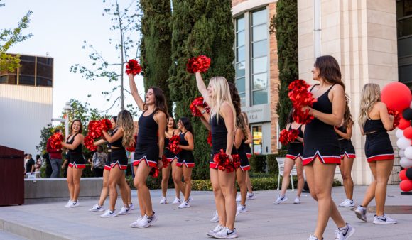 cheerleaders in black and red on library steps