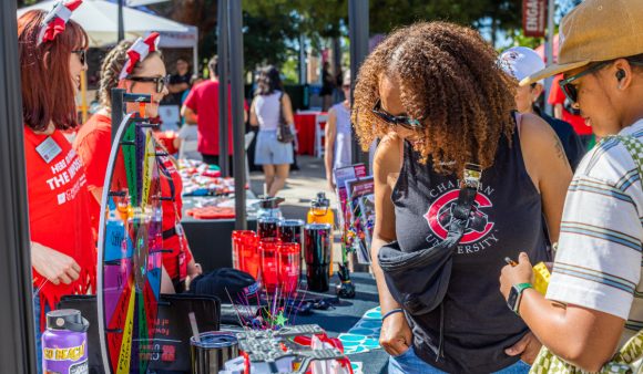 woman in chapman t-shirt browses booth