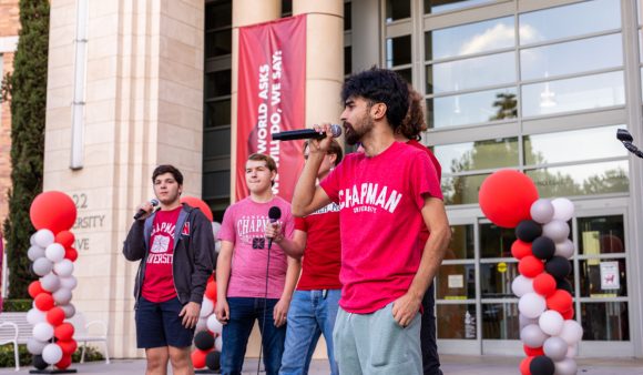 male singers in red chapman t-shirts on library steps