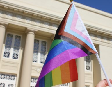 LGBTQIA+ flag in front of Chapman campus building