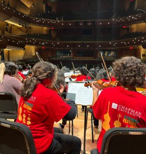 music students in chapman strings festival tshirts on stage at the musco center looking out over the auditorium